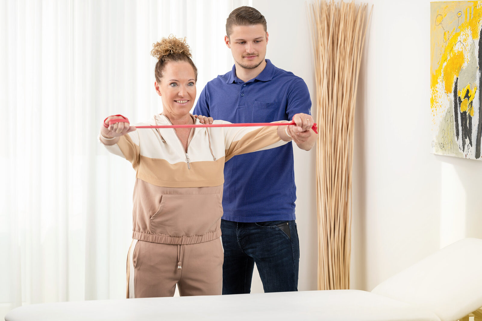 Physiotherapeut mit Patientin bei Physiotherapie